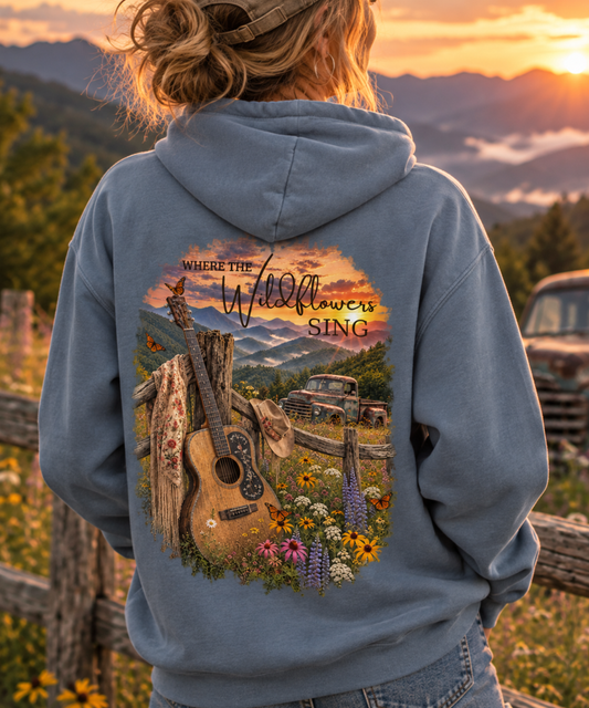 Woman wearing a vintage music hoodie with wildflowers and guitar inspired outdoor graphic