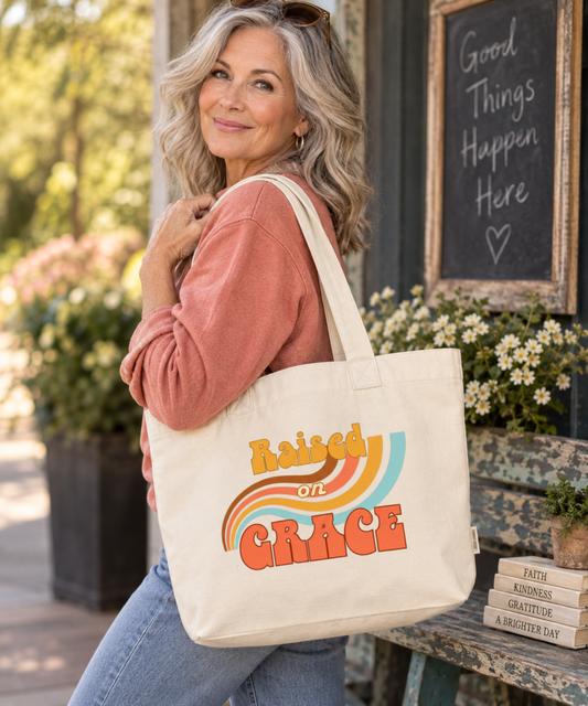 Woman carrying ivory Raised on Grace Christian canvas tote with colorful retro rainbow design.