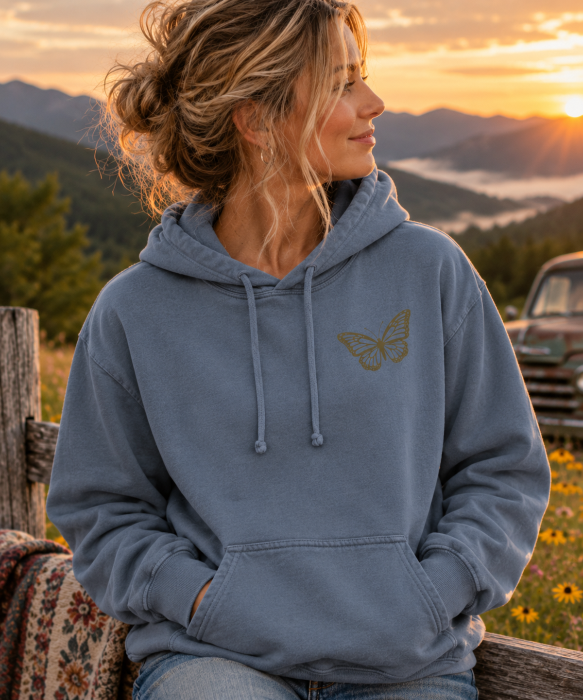 Woman wearing blue jean comfort colors   vintage music hoodie with butterfly left chest design in mountain setting