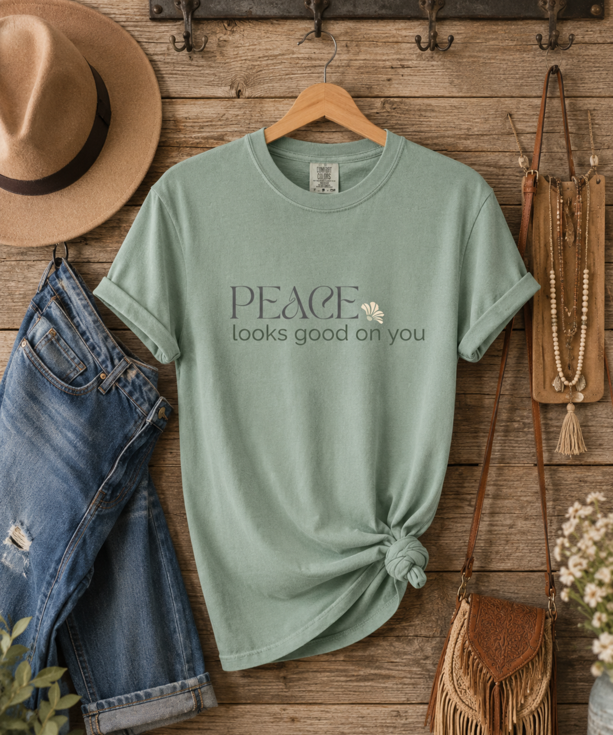 Flat lay of a Bay Comfort Colors 1717 t-shirt featuring the phrase "Peace looks good on you."