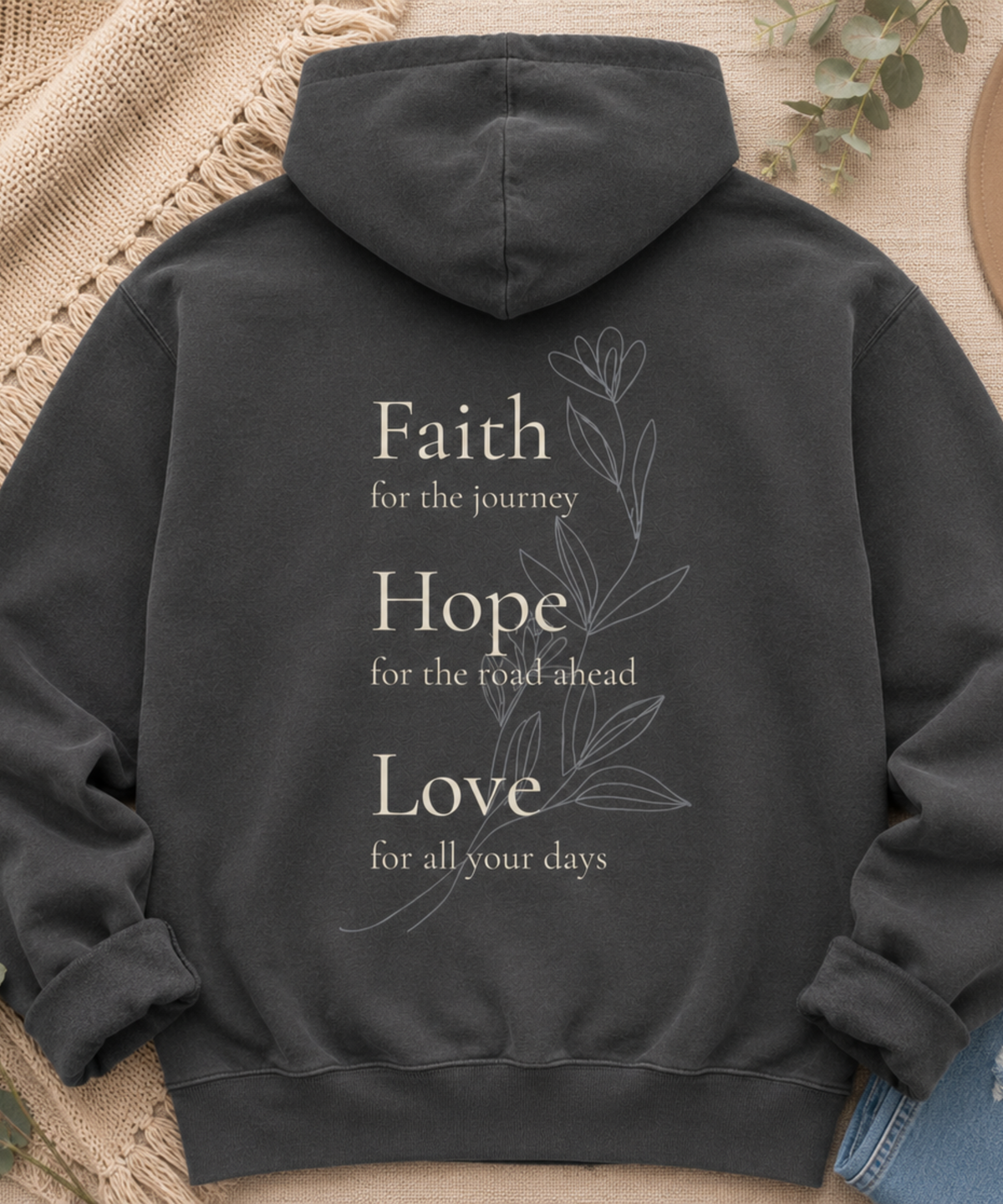 Flat lay of Comfort Colors pepper hoodie featuring Faith Hope Love botanical inspirational back print