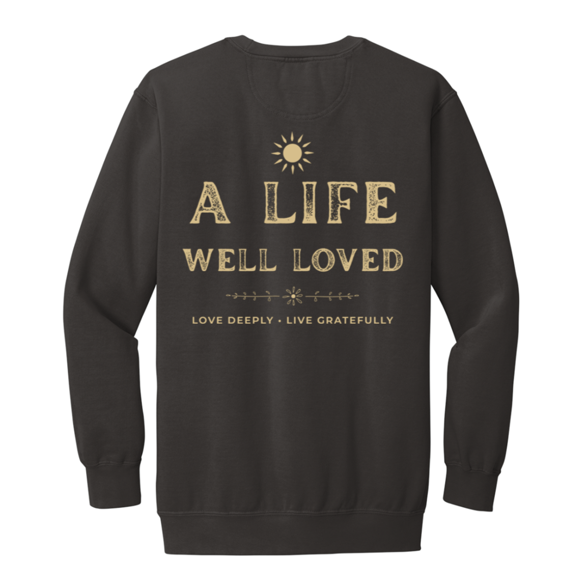 A pepper crewneck sweatshirt shown from the back, featuring a gold graphic print with a sun icon and the text 'A LIFE WELL LOVED' and 'LOVE DEEPLY • LIVE GRATEFULLY'.