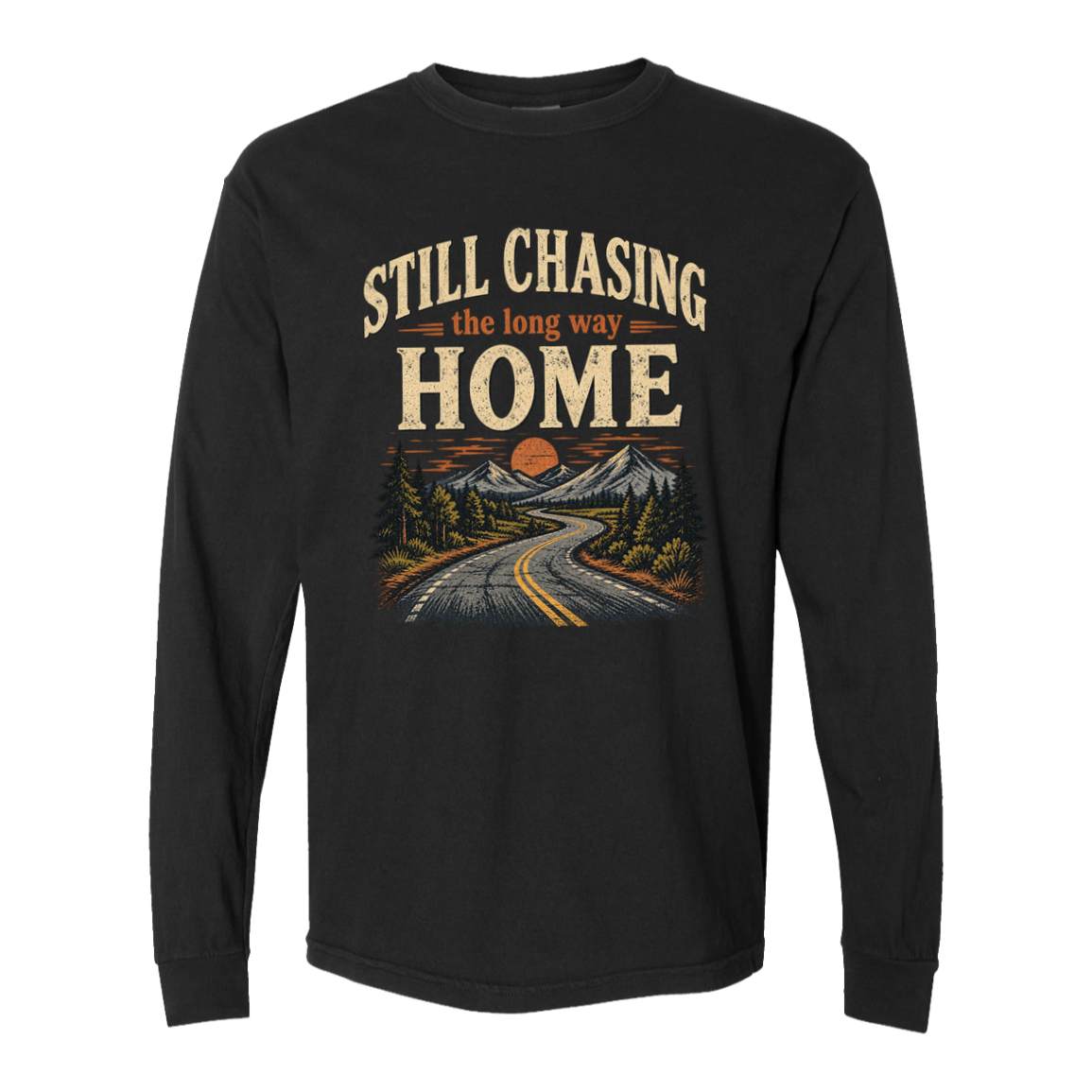 A black long-sleeve t-shirt with a vintage-style graphic on the chest that reads 'STILL CHASING the long way HOME' above an illustration of a winding road, mountains, and trees at sunset.