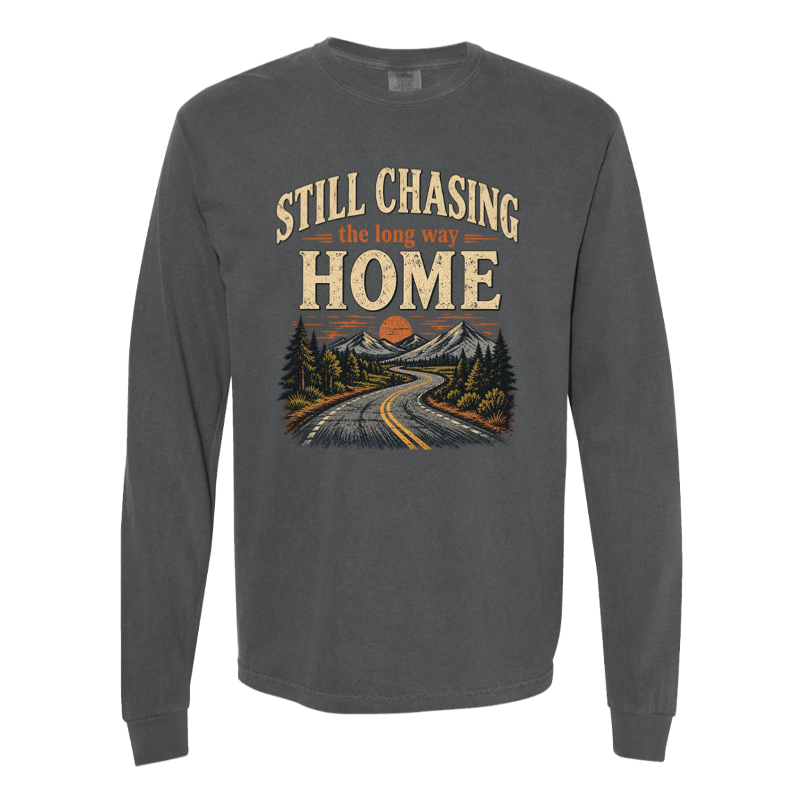A pepper colored long-sleeve t-shirt with a vintage-style graphic on the chest that reads 'STILL CHASING the long way HOME' above an illustration of a winding road, mountains, and trees.