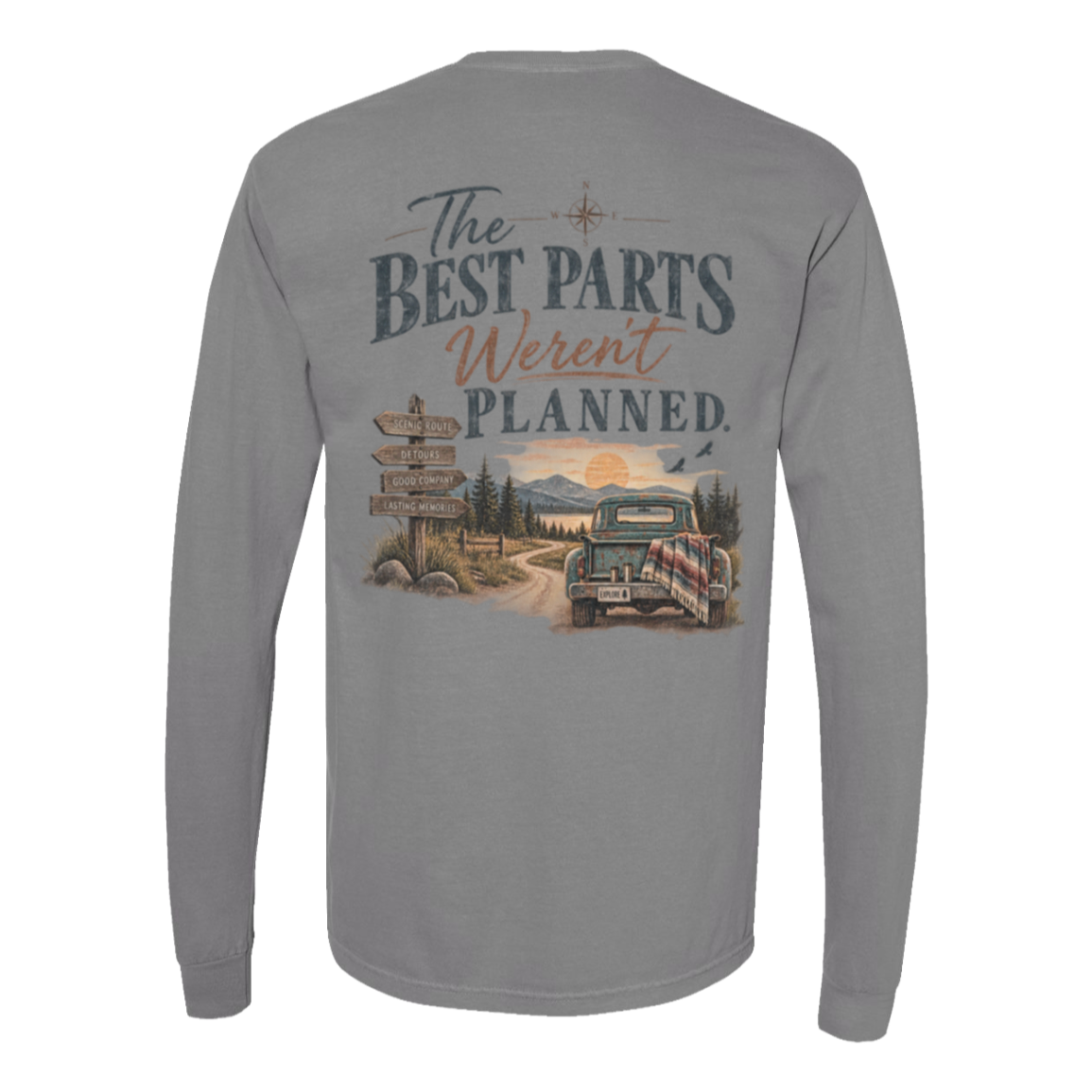 A gray long-sleeve t-shirt shown from the back, featuring a large graphic print with the text 'The BEST PARTS Weren't PLANNED.' above an illustration of a vintage pickup truck on a dirt road with mountains and a sunset.