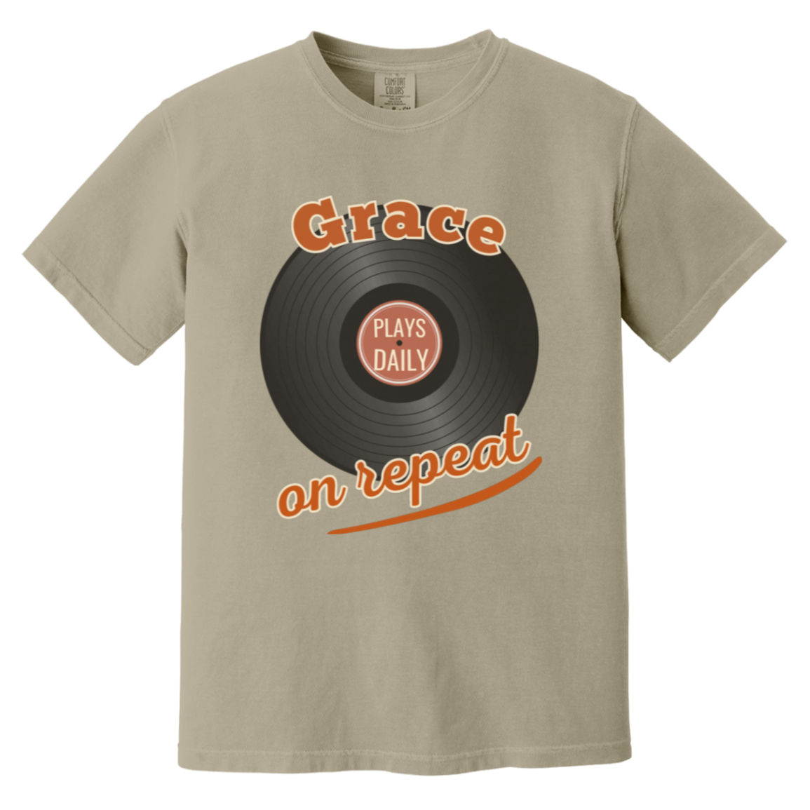 A sandstone comfort colors short-sleeve crewneck t-shirt featuring a retro graphic of a black vinyl record with orange text reading 'Grace on repeat' and a smaller inner label that says 'PLAYS DAILY'.