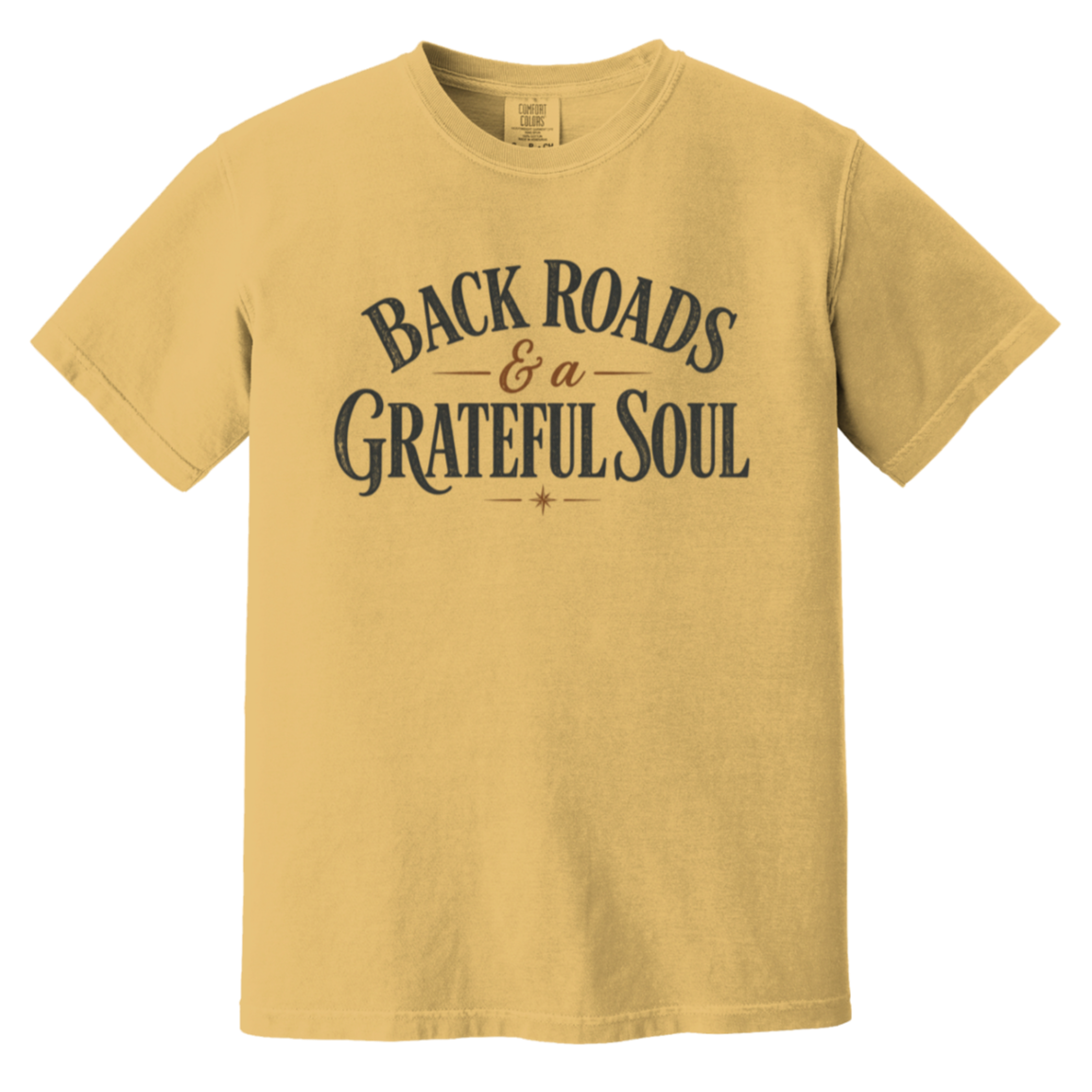 A mustard yellow short-sleeve t-shirt with a dark gray distressed graphic text print reading 'BACKROADS & a GRATEFUL SOUL' on the chest.