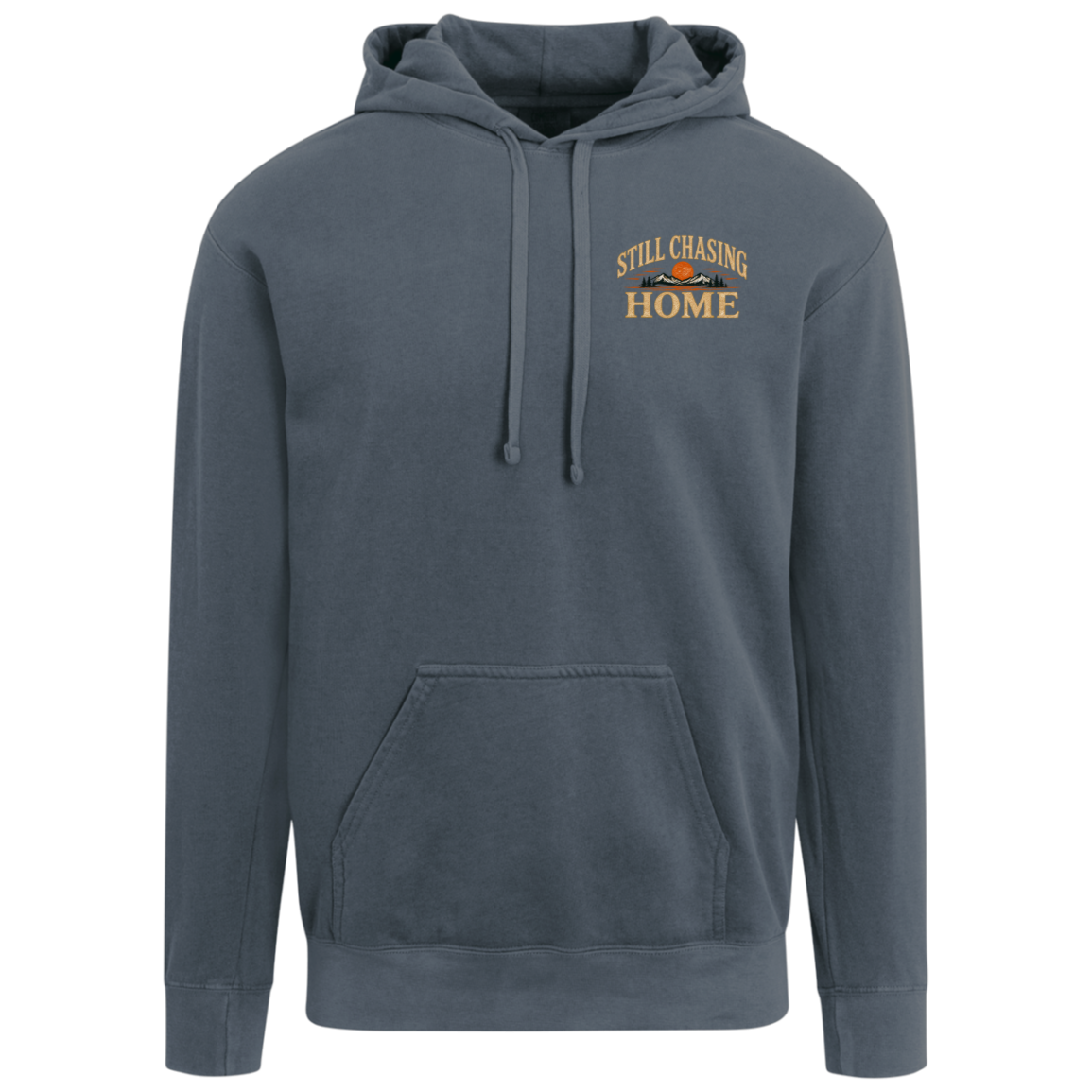 A denim comfort colors pullover hoodie with a drawstring hood, kangaroo pocket, and a small embroidered graphic on the left chest reading 'STILL CHASING HOME' above a mountain and sun design. Includes full back design.