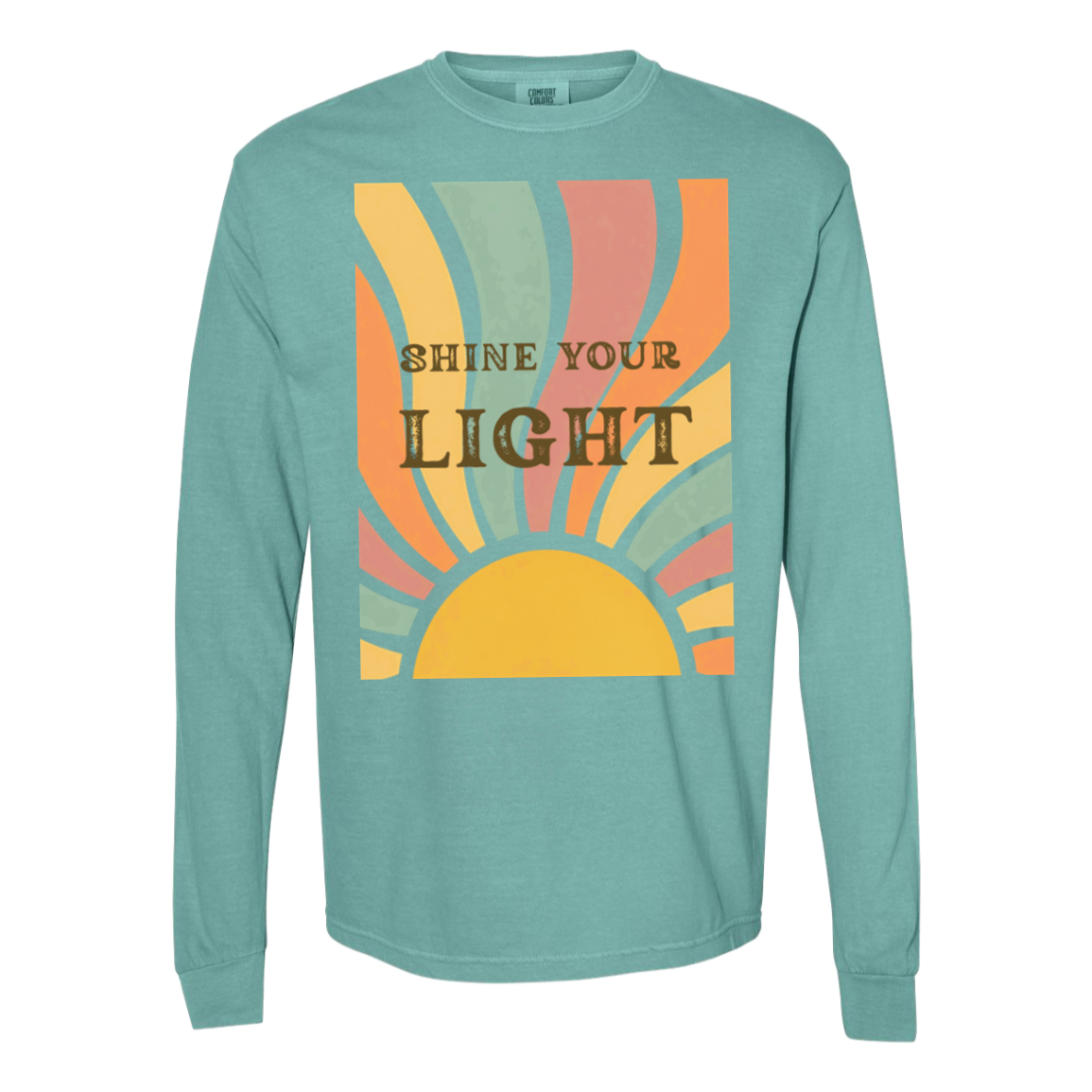 A long-sleeve comfort colors  crewneck t-shirt in seafoam, featuring a retro-style graphic on the chest with a yellow sun and pastel stripes in orange, pink, and green, with the text 'SHINE YOUR LIGHT' in brown.
