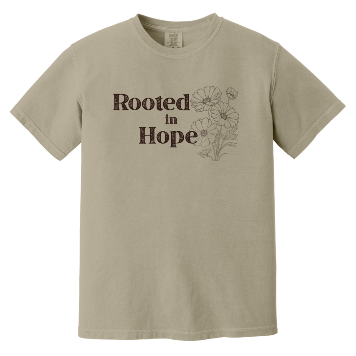 Vintage-inspired Comfort Colors Sand stone colored t-shirt featuring the phrase “Rooted in Hope” with soft botanical artwork in earthy muted tones.