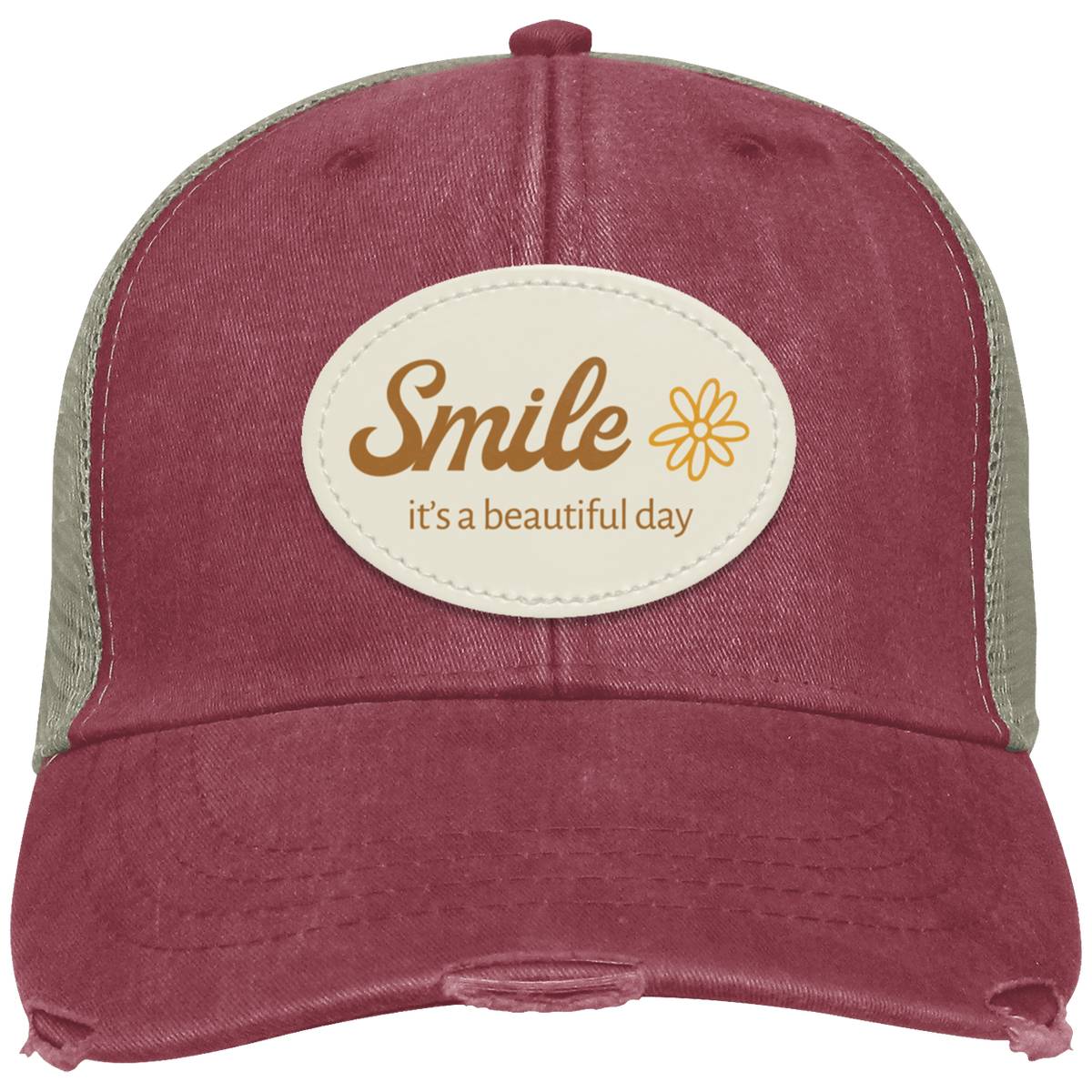 A distressed trucker hat in washed nautical red with tan mesh side panels and a center cream oval patch that reads 'Smile it's a beautiful day' with a small flower graphic.