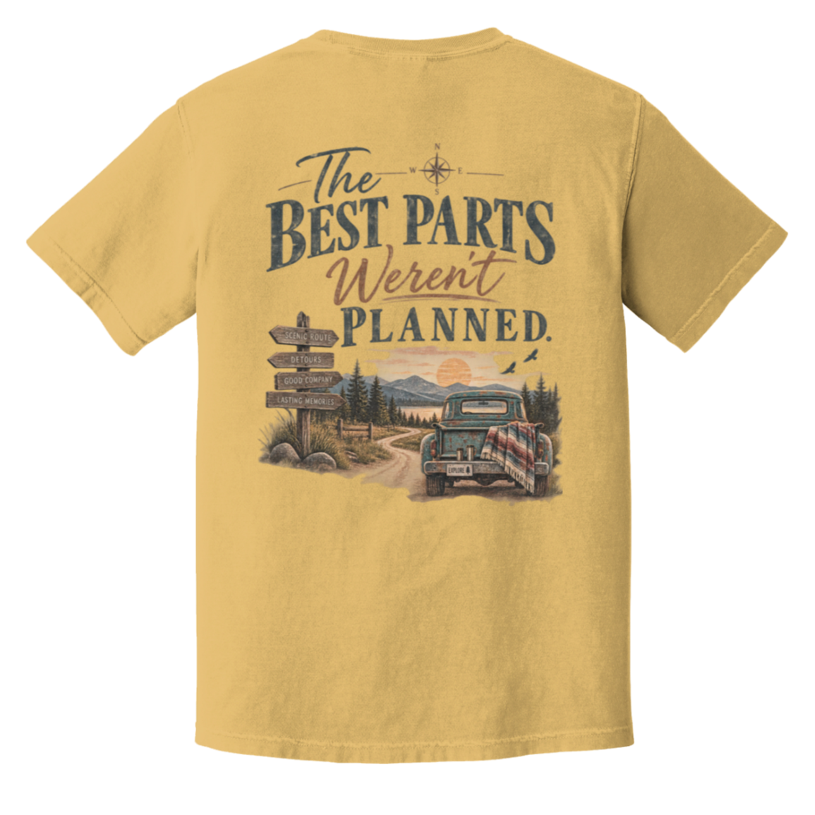 A mustard short-sleeve t-shirt shown from the back, featuring a large graphic print with the text 'The Best Parts Weren't Planned.' above an illustration of a vintage pickup truck on a dirt road with mountains and a sunset.