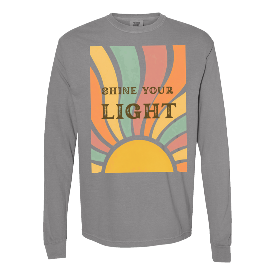 A gray long-sleeve comfort colors  crewneck t-shirt featuring a retro-style graphic print on the front with a semi-circle sun and rays in yellow, orange, peach, and mint green, with the text 'SHINE YOUR LIGHT' in brown.