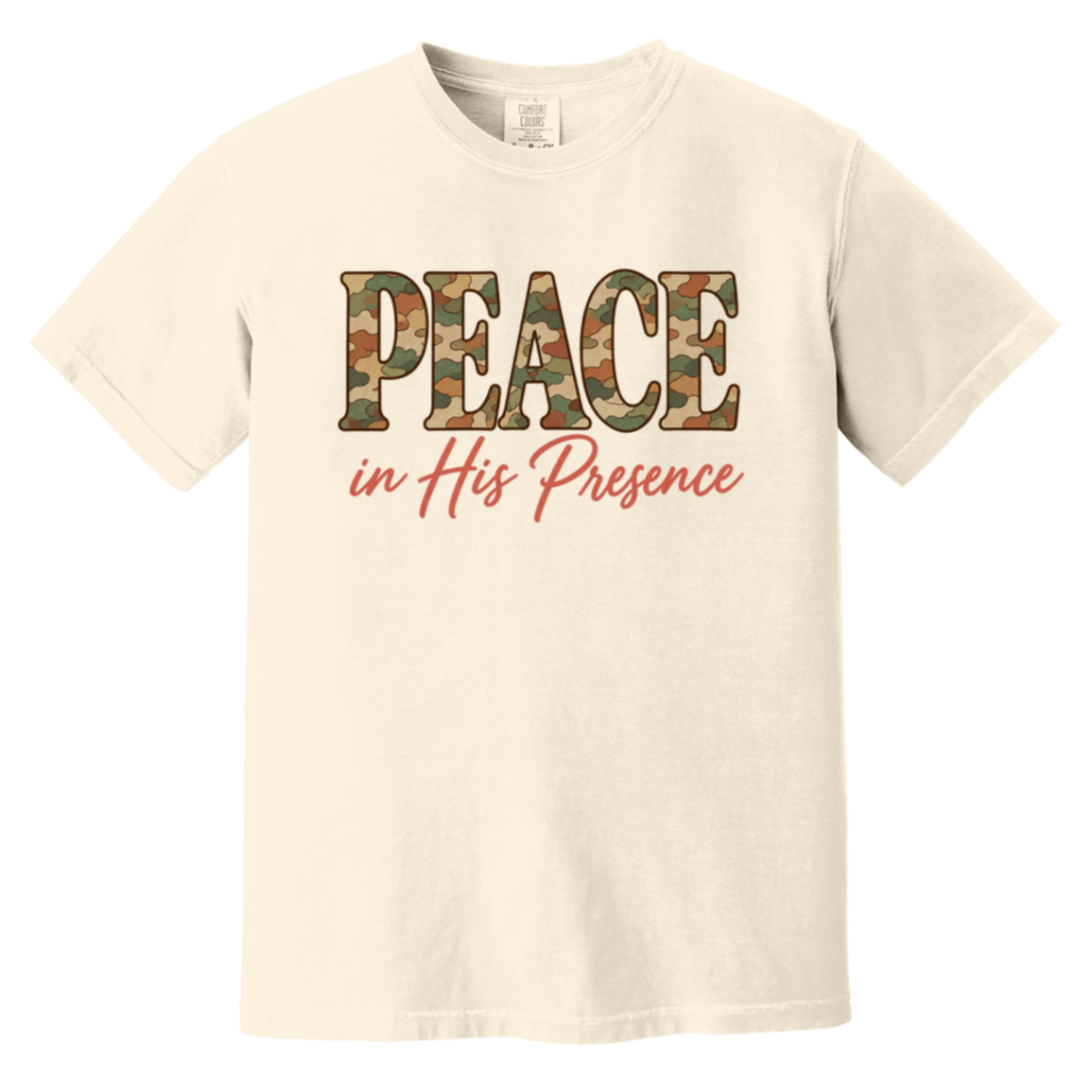 An ivory comfort colors t-shirt featuring a graphic print on the chest. The word 'PEACE' is printed in a camouflage pattern, and below it, the phrase 'in His Presence' is written in a coral pink cursive font.