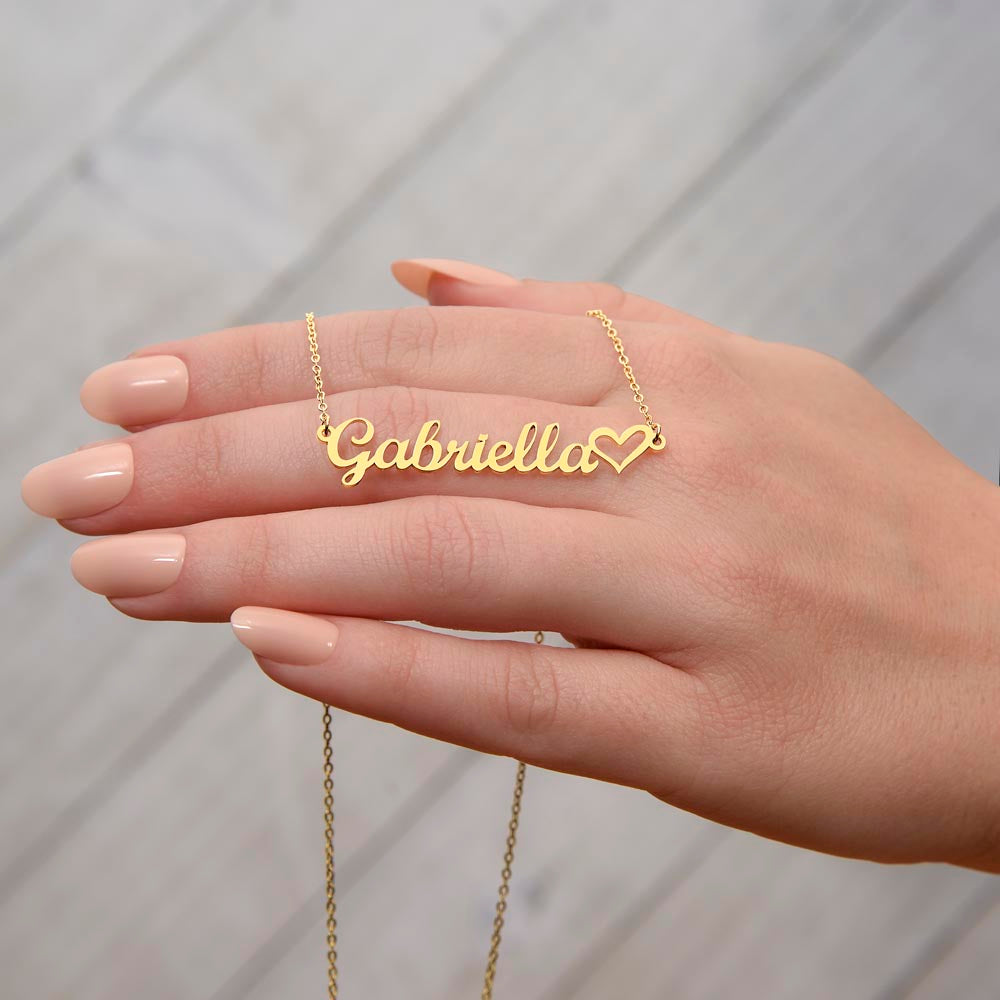 Gold daughter name necklace draped across a woman's hand