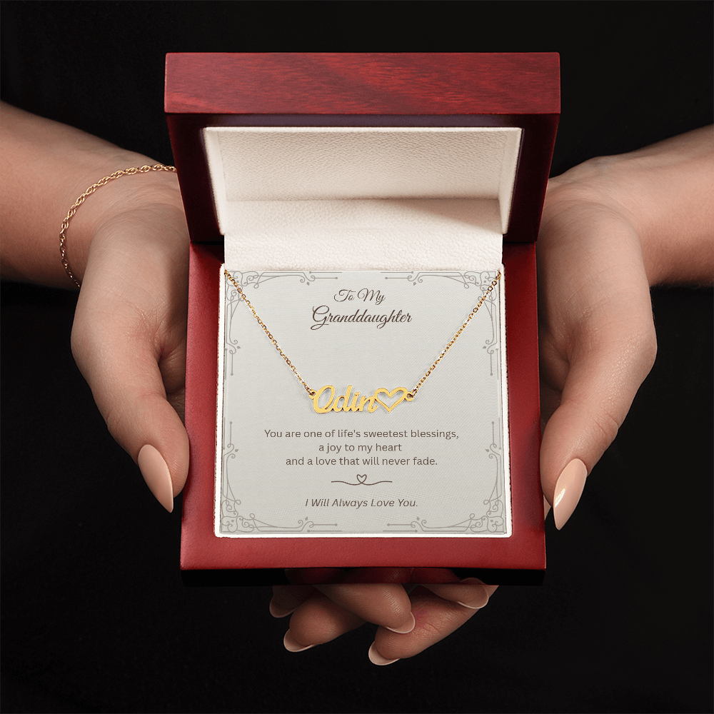 Hand holding personalized granddaughter necklace in luxury gift box