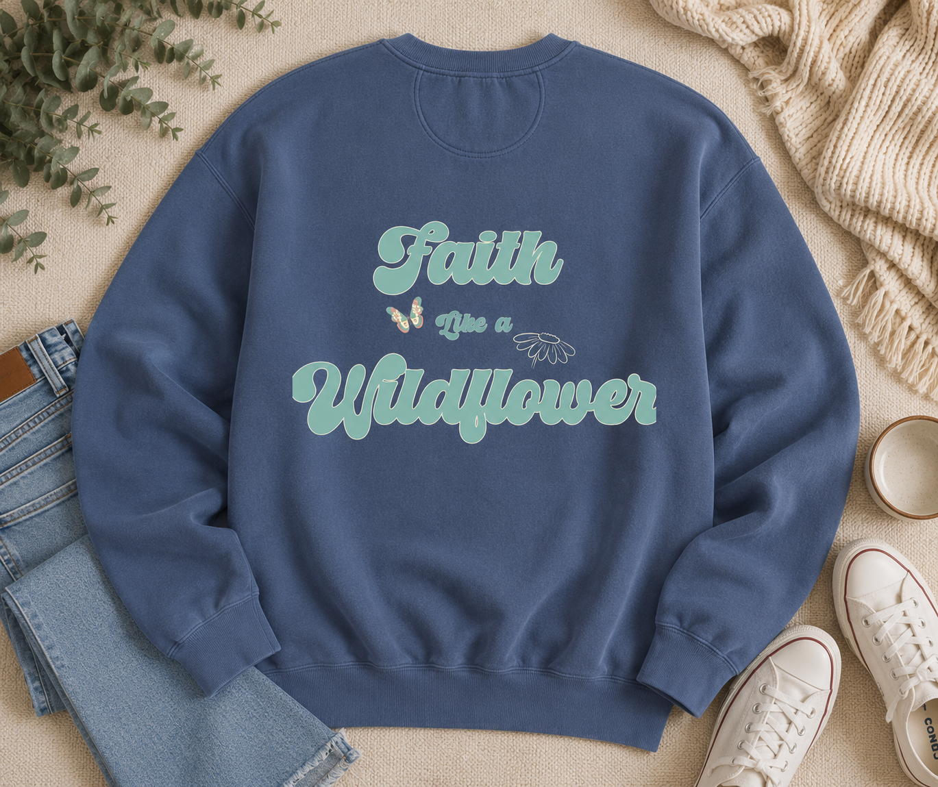Flat lay of Comfort Colors Blue Jean crewneck sweatshirt featuring Faith Like Wildflower vintage floral back graphic