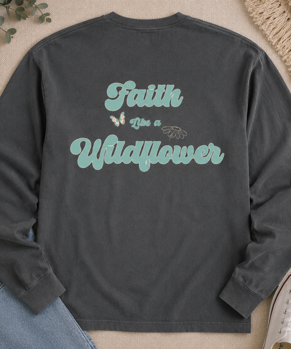 Flat lay of Comfort Colors pepper long sleeve shirt with Faith Like a Wildflower floral back graphic.