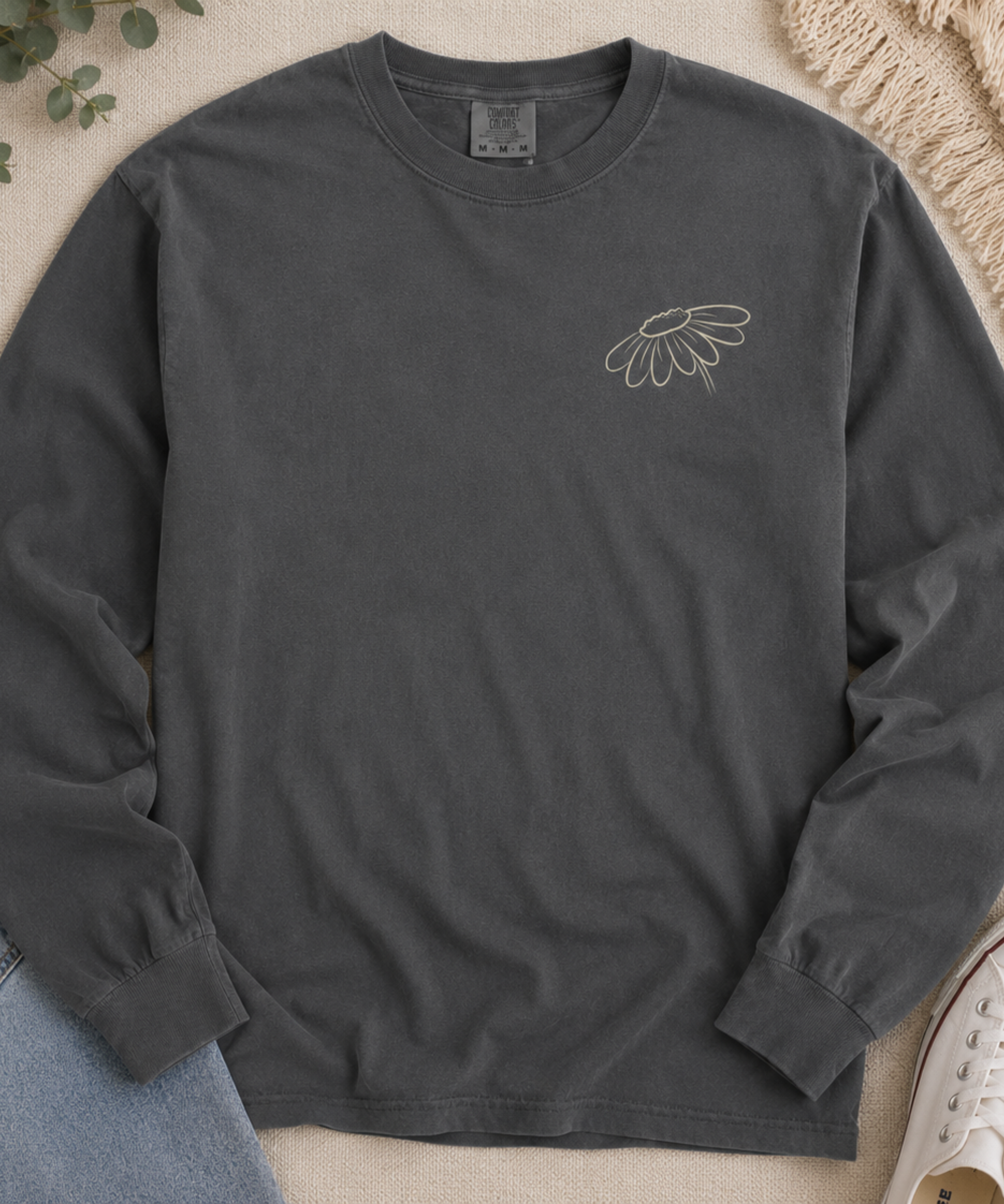 Flat lay of Comfort Colors pepper long sleeve shirt with small wildflower left chest graphic.