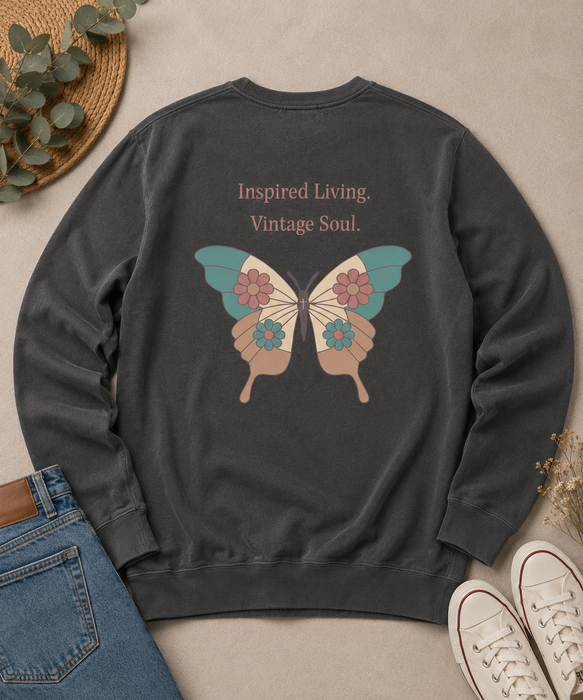 Flat lay of a Comfort Colors Pepper crewneck sweatshirt featuring the Inspired Living. Vintage Soul. butterfly back design, styled with blue jeans, canvas sneakers, and natural accents.