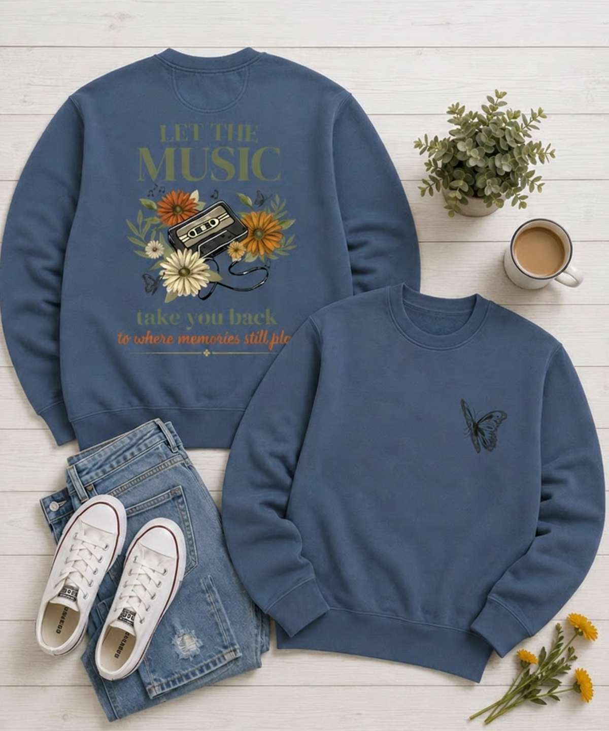 "Blue Comfort Colors crewneck sweatshirt flat lay featuring a vintage music cassette and wildflower back design with butterfly left chest detail, styled with denim jeans, sneakers, coffee mug, and flowers."