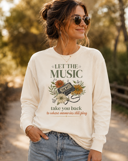 Woman wearing Comfort Colors Ivory long sleeve shirt featuring the "Let the Music Take You Back to Where Memories Still Play" vintage cassette and floral graphic.