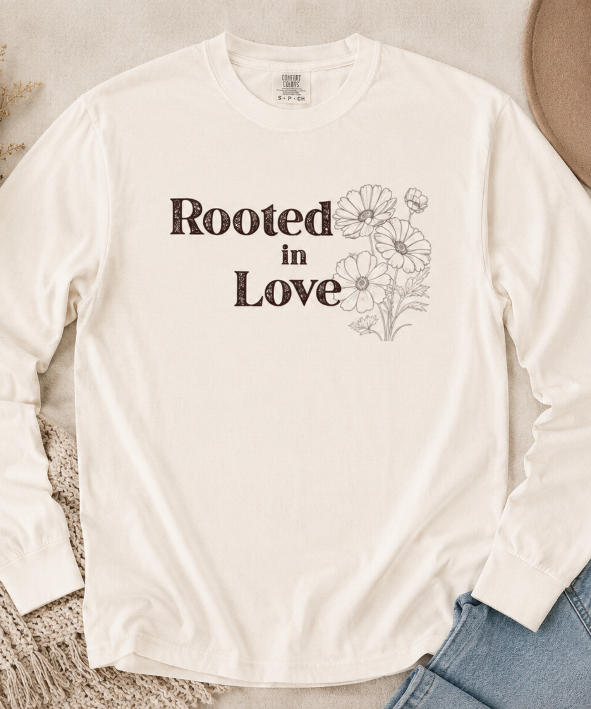Flat lay of Comfort Colors Ivory long sleeve shirt featuring Rooted in Love vintage floral faith design