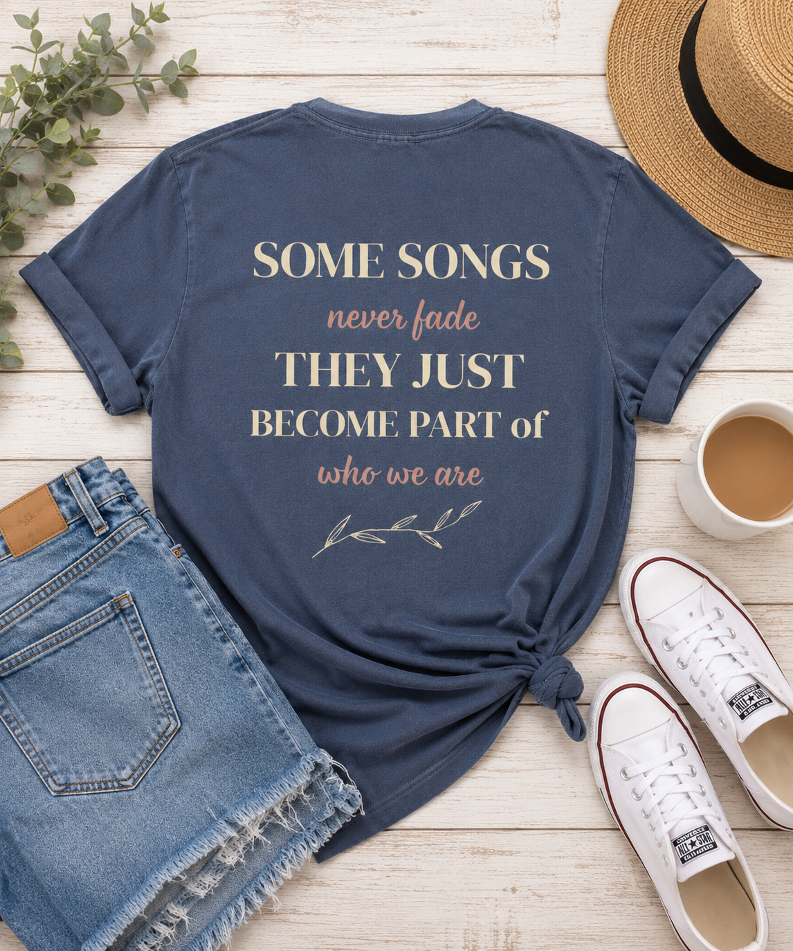 Flat lay of faded blue Comfort Colors t-shirt featuring nostalgic music quote "Some Songs Never Fade, They Just Become Part of Who We Are."