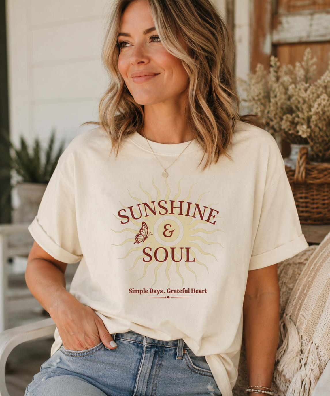 Woman wearing an ivory Comfort Colors® Sunshine & Soul t-shirt featuring a vintage sunburst graphic, butterfly accent, and the phrase "Simple Days • Grateful Heart" in warm maroon tones.